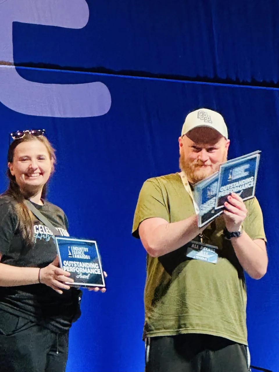 Dixon holding Outstanding Performance plaques on stage
