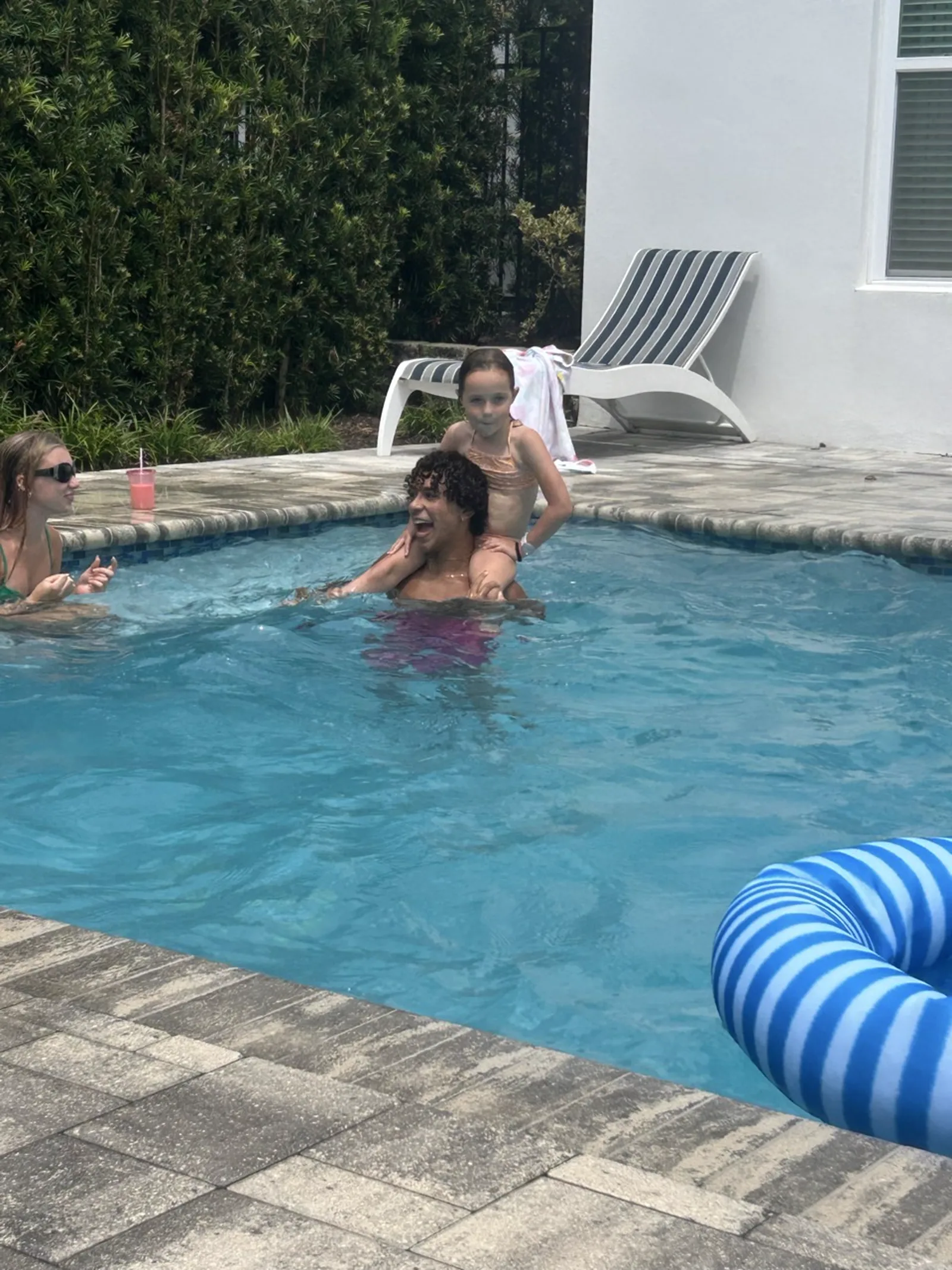 Marilynn on John's shoulders in the pool at the kickoff sleepover