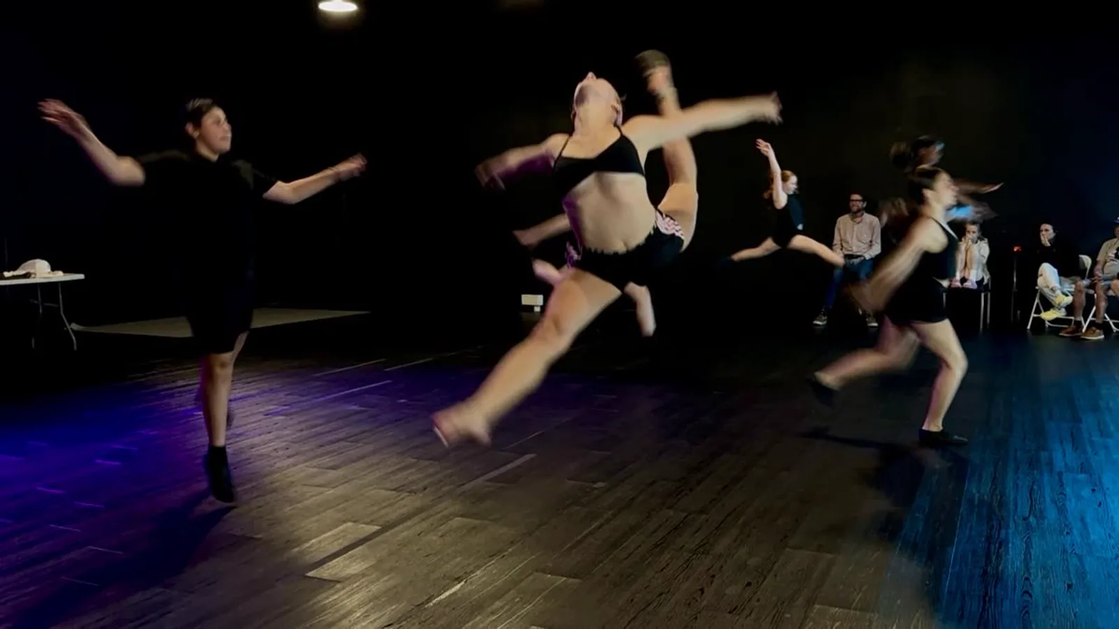 Daisy mid-air in a firebird jump at the Summer Intensive showcase